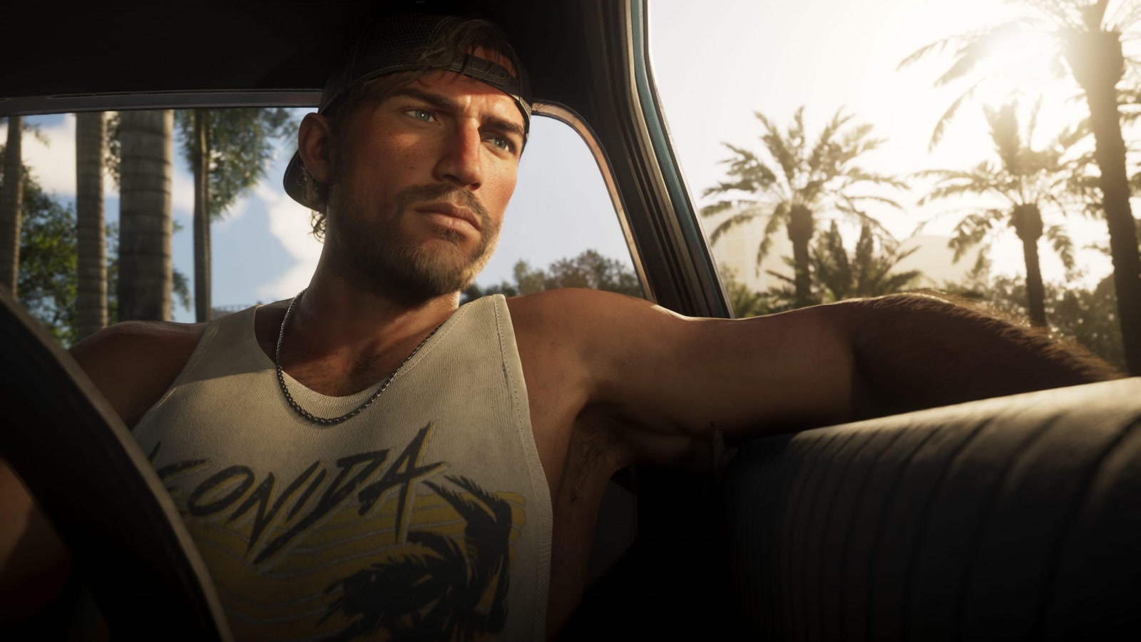 Grand Theft Auto VI still of Jason Duval driving, palm trees in the windshield